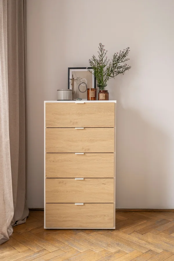 Komoda z pięcioma szufladami w minimalistycznym wnętrzu.